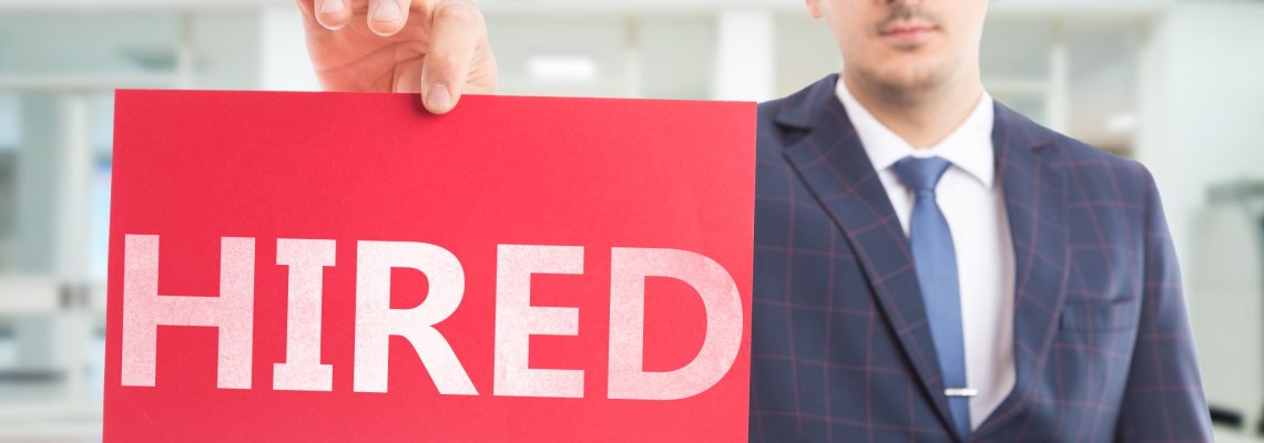 Employee presenting red paper with hired text as found job concept